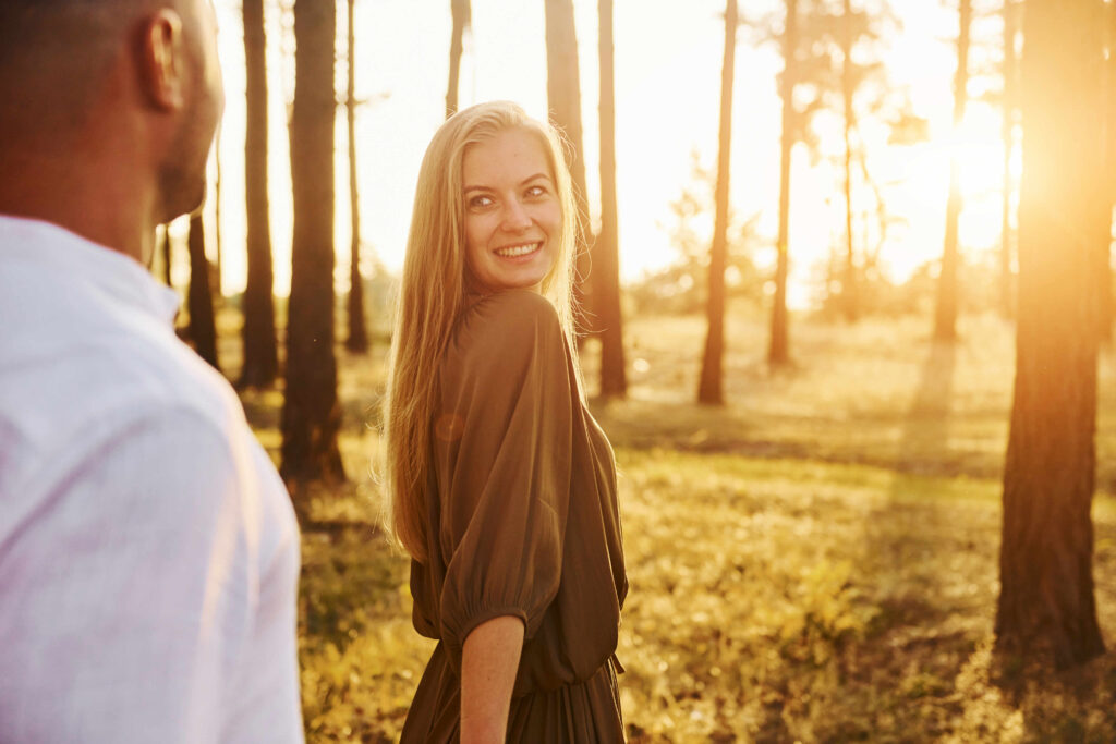 tenderness and hapiness. couple is outdoors in the forest at daytime
